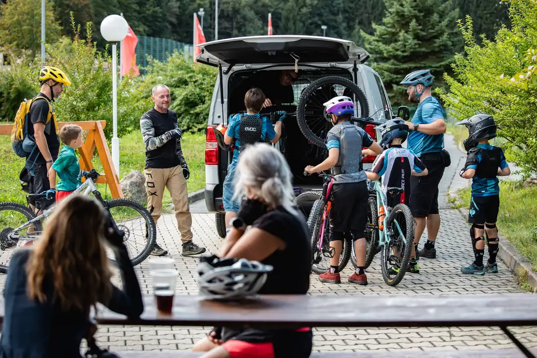 Eine Gruppe mit Mountainbikes und Helmen trifft sich am Shuttlefahrzeug.