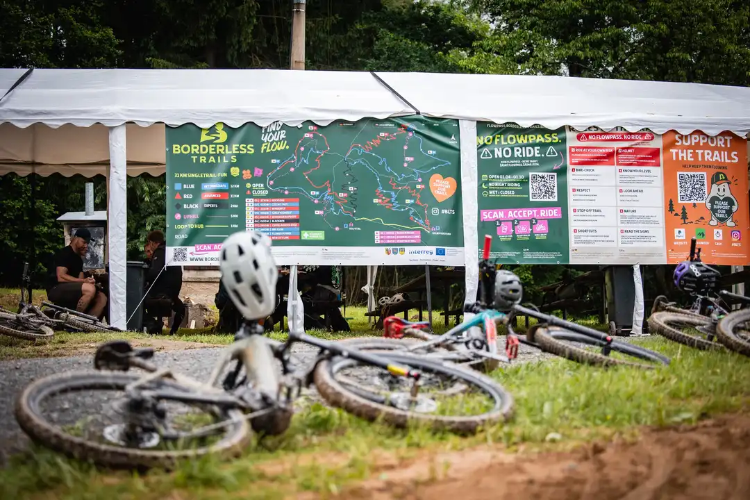 Basecamp der Borderless Trails mit Trailkarte, Infotafeln und abgestellten Mountainbikes.